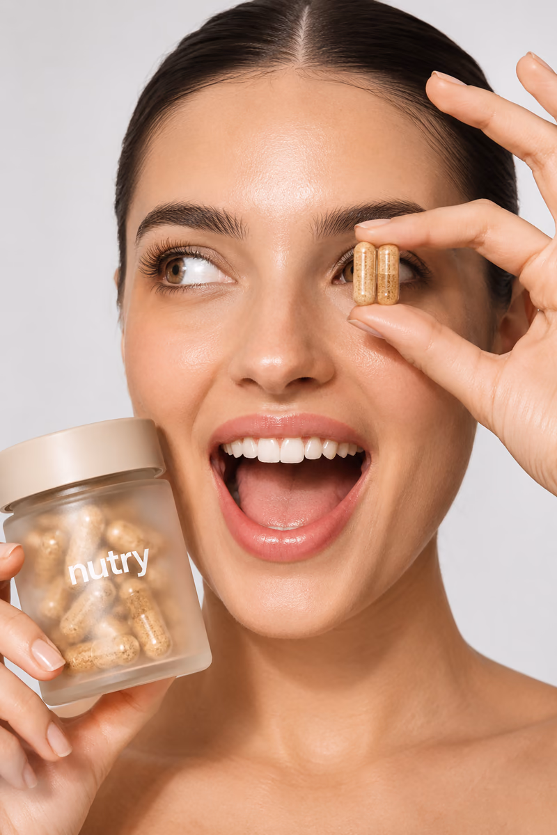Smiling woman holding a Nutry capsule and jar